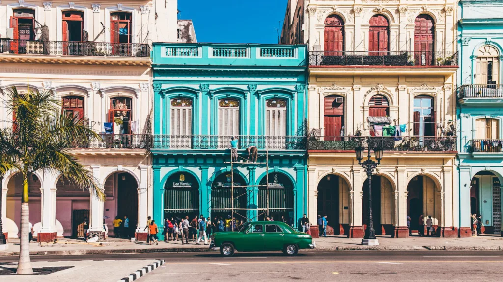 Vibrant colonial buildings and classic car on a sunny street in Havana, Cuba.