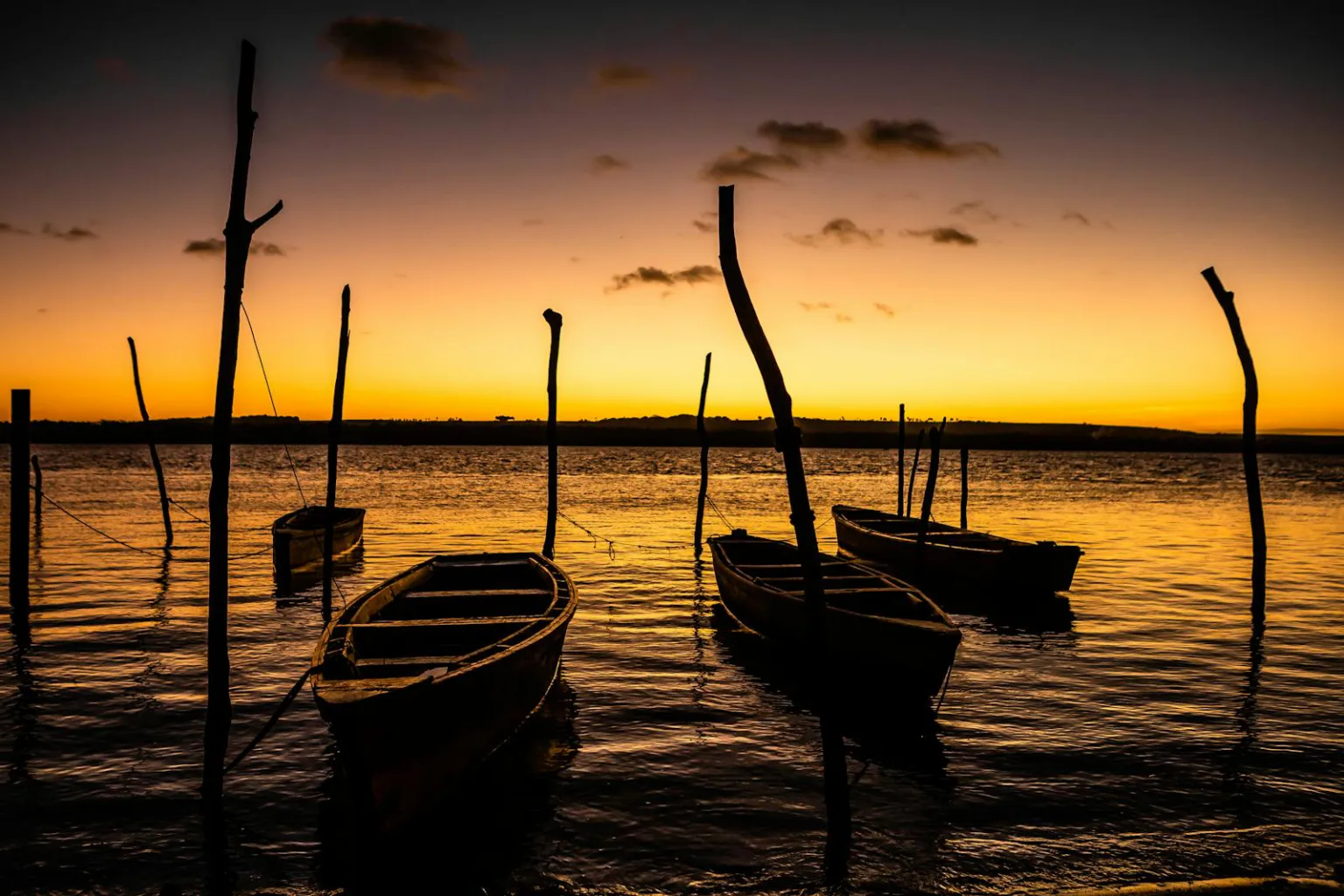 Moored boats at sunset in Paraíba, Brazil create a tranquil scene.